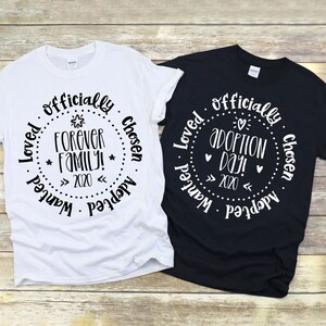 Puede incluir: Dos camisetas, una blanca y otra negra, con un dise&ntilde;o circular que dice "Loved officially chosen adopted wanted" y "Forever family! 2020" en la camiseta blanca y "Loved officially chosen adopted wanted" y "Adoption Day! 2020" en la camiseta negra.