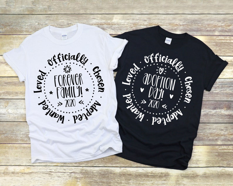 Puede incluir: Dos camisetas, una blanca y otra negra, con un dise&ntilde;o circular que dice "Loved officially chosen adopted wanted" y "Forever family! 2020" en la camiseta blanca y "Loved officially chosen adopted wanted" y "Adoption Day! 2020" en la camiseta negra.