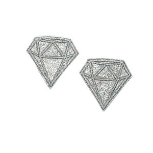 Puede incluir: Dos pendientes de plata con forma de diamante y purpurina.