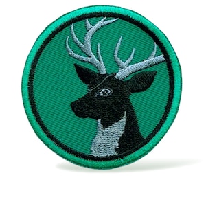 Könnte beinhalten: Gestickter Aufnäher mit einem schwarzen Hirschkopf, weißem Geweih und Brust, auf einem grünen Kreis. Der Aufnäher hat einen grünen Rand. Ideal für Kleidung oder Accessoires.