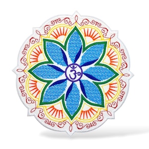 Pode incluir: Remendo bordado circular com um desenho de flor de lótus azul e um símbolo Om no centro. A flor tem pétalas verdes e azuis, detalhes em laranja e amarelo e uma borda vermelha.
