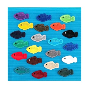 Può includere: Una collezione di 18 pesci di feltro colorati, ognuno con un design unico. I pesci sono disposti in una griglia su uno sfondo blu.