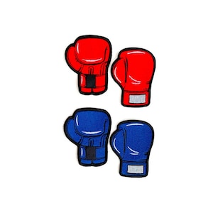 May include: Four embroidered patches of boxing gloves. Two are red, and two are blue. Each glove has a black outline and a white rectangle on the wrist area. The gloves are arranged in pairs, with each pair facing the same direction.