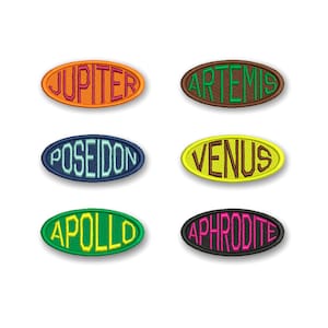 Puede incluir: Seis parches bordados de forma ovalada con diferentes nombres en varios colores. Los nombres son: Júpiter, Artemisa, Poseidón, Venus, Apolo y Afrodita.
