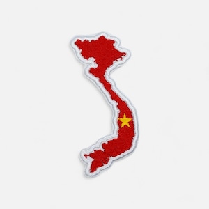 May include: A red embroidered patch in the shape of Vietnam, with a white border. The patch features a yellow star in the lower portion, representing the flag of Vietnam. The patch is likely for clothing or accessories.