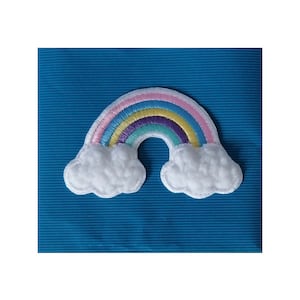 May include: An embroidered patch featuring a rainbow with fluffy white clouds on either side. The rainbow has pink, yellow, green, blue, and purple stripes.