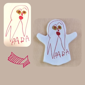 May include: A white felt hand puppet shaped like a ghost with red embroidered details. The ghost has a red mouth, two yellow eyes, and the word "PARA" embroidered on the front.