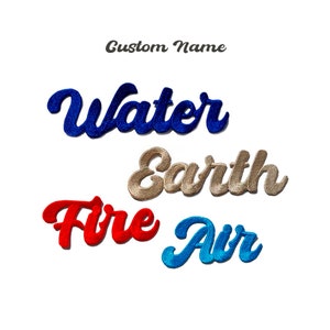 Może przedstawiać: Cztery haftowane łatki z napisami "Water", "Earth", "Fire" i "Air" w stylizowanym kroju pisma. Łatki są odpowiednio w kolorze niebieskim, złotym, czerwonym i niebieskim.