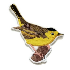 Può includere: Toppa ricamata da stirare con un parula gialla appollaiato su un ramo. L'uccello ha una calotta nera e un petto giallo.