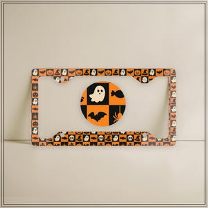 May include: Halloween-themed license plate frame with a repeating pattern of ghosts, pumpkins, and bats on an orange and black checkered background. A matching round coaster features a ghost, bat, and spider design.