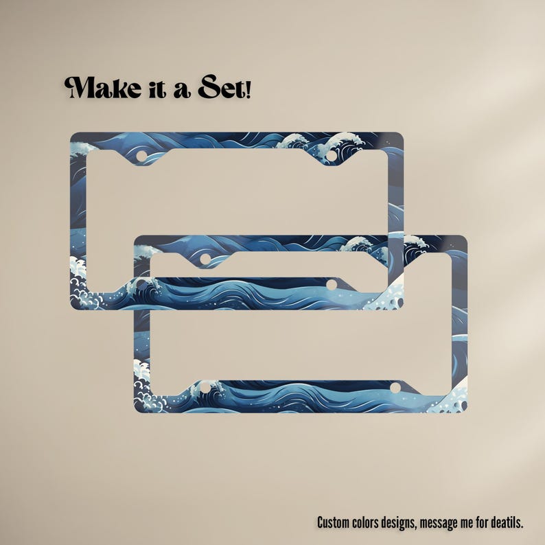 The Coastal Ocean Waves and deep navy, cobalt blue, and white license plate frame mounted on a Jeep at the beach, showcasing the design in natural outdoor sunlight.