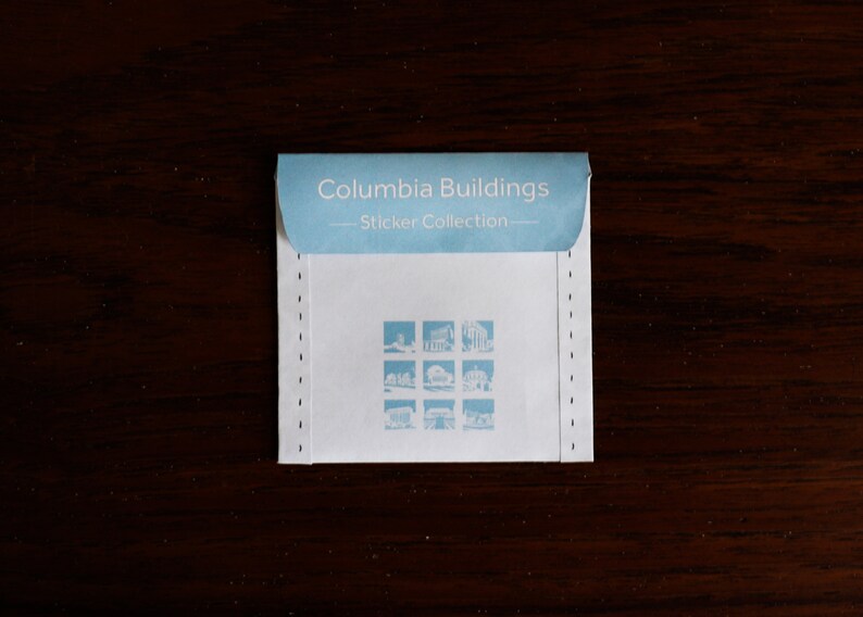 Puede incluir: Un sobre blanco con texto azul que dice "Columbia Buildings - Sticker Collection -" y presenta una cuadr&iacute;cula de nueve peque&ntilde;as im&aacute;genes de edificios.