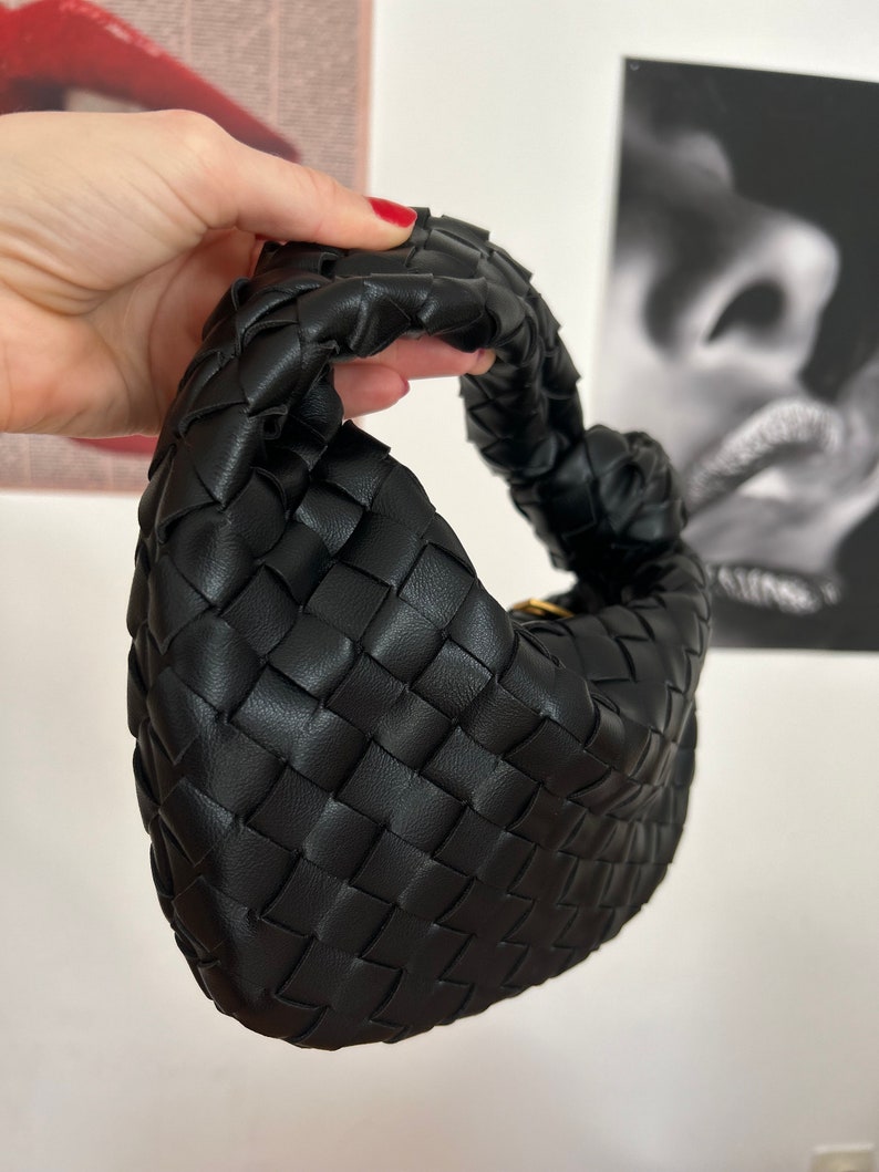 Handcrafted with high-quality vegan leather, this pouch is both cruelty-free and eco-friendly. Add a touch of sophistication to your everyday look with this must-have accessory!vegan leather bottega veneta inspired clutch bag in black colour.