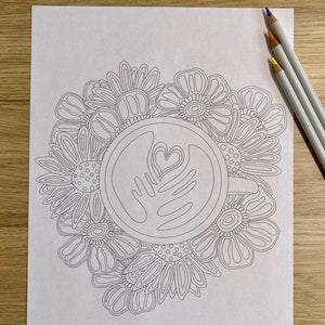 K&ouml;nnte beinhalten: Eine Schwarzwei&szlig;-Zeichnung einer Kaffeetasse mit floralem Design. Die Tasse hat ein herzf&ouml;rmiges Design im Schaum. Die Blumen sind stilisiert und haben einen verspielten Charakter. Der Text "jcarp designs" befindet sich am unteren Rand des Bildes.