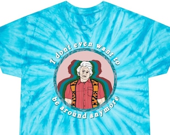May include: A turquoise tie-dye t-shirt with a circular graphic of a man with white hair and a red and orange patterned shirt. The graphic has the text "I don't even want to be around anymore".