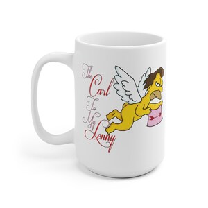 May include: White ceramic mug with a cartoon image of a yellow angel with wings, holding a pink arrow. The text "The Carl To My Lenny" is written in red cursive on the mug.