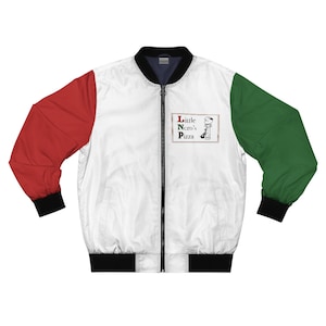 Pu&ograve; includere: Giacca bomber bianca con maniche rosse e verdi. La giacca ha colletto, polsini e orlo neri. La parte anteriore della giacca presenta una piccola toppa rettangolare con la scritta "Little Ncro's Pizza" e un'immagine a cartoni animati.