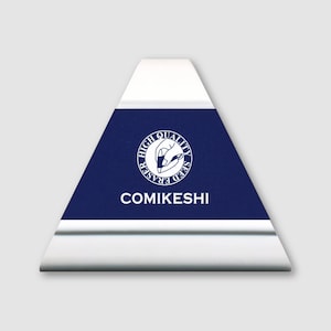 May include: A white and navy blue triangular eraser with the text "COMIKESHI" and a circular logo. The eraser has a silver metal edge. The logo reads "HIGH QUALITY SEED ERASER".