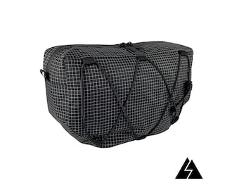 May include: Black rectangular bag with a grid pattern and a zipper closure. The bag has a drawstring closure and a small logo on the bottom.