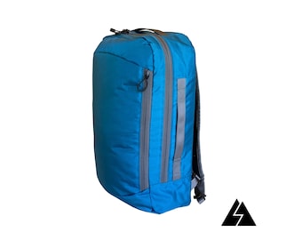 May include: A blue travel backpack with a zippered front pocket and a handle on the side. The backpack has a black strap and a black zipper.