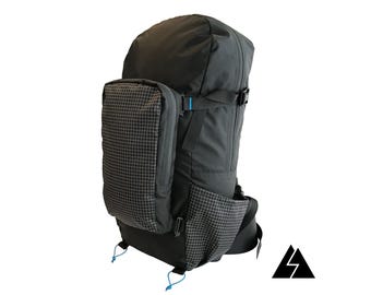 May include: A black backpack with a blue zipper and a small, black, grid-patterned pocket on the front. The backpack has a large main compartment and a smaller pocket on the front.