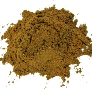 May include: A close-up of a pile of ground cinnamon, a brown spice with a warm, sweet aroma.
