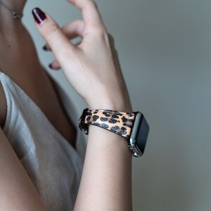 May include: A silver smartwatch with a black and brown leopard print band.