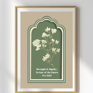 Peut inclure: Impression d'art encadrée avec un motif floral. Des fleurs blanches se détachent sur un fond vert, avec le texte "Strength & Dignity: No fear of the future Pro 31:25". L'impression est dans un cadre doré, idéale pour la décoration intérieure.
