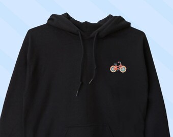 Op de afbeelding: Zwart hoodie met een klein geborduurd beeld van een rode fiets op de voorkant.