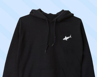May include: Black hooded sweatshirt with a small white shark graphic on the front.