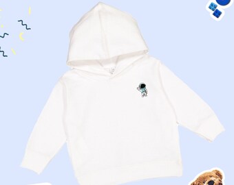 May include: White hooded sweatshirt with a small astronaut graphic on the front.