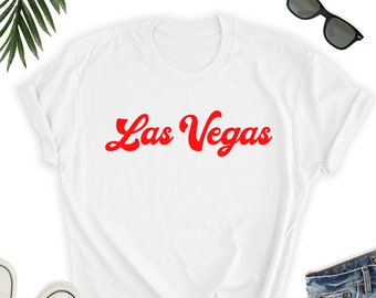 May include: White t-shirt with the text "Las Vegas" in red, retro-style font.