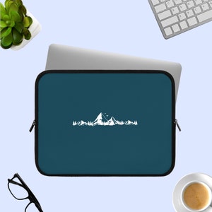 May include: A dark blue laptop sleeve with a white mountain range design. The sleeve has a zipper closure.
