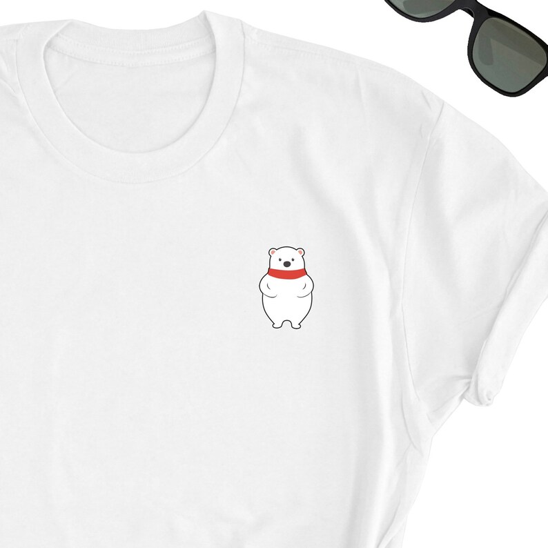 May include: White t-shirt with a small embroidered image of a white polar bear wearing a red scarf.