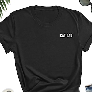 May include: Black t-shirt with the text "CAT DAD" in white lettering.