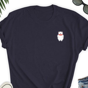 May include: A navy blue t-shirt with a white polar bear wearing a red scarf on the front.
