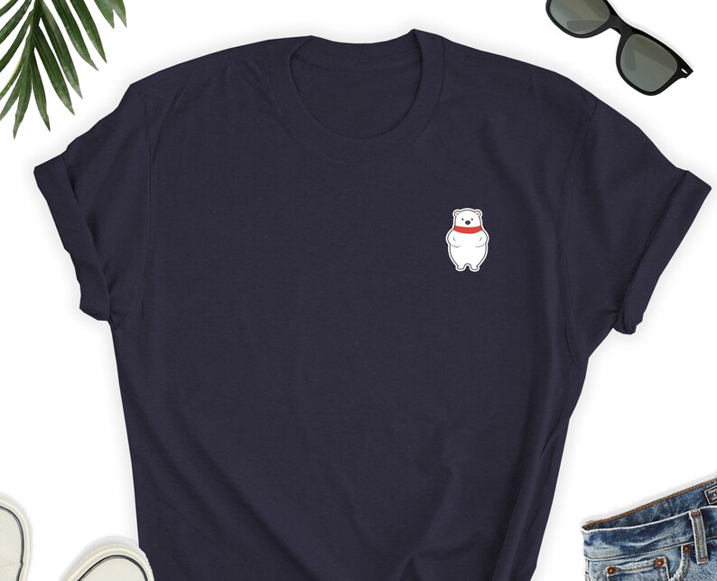 May include: A navy blue t-shirt with a white polar bear wearing a red scarf on the front.