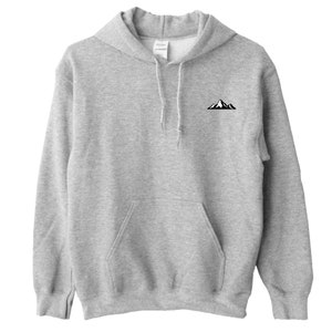 Op de afbeelding: Een lichtgrijze hoodie met een voorzak en een trekkoord. Een kleine zwart-witte bergafbeelding staat op de linkerbovenborst. De hoodie is gemaakt van een zacht, comfortabel materiaal.