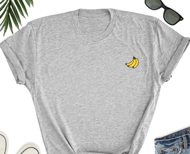 May include: A gray t-shirt with a small yellow banana graphic on the front.