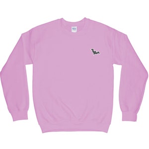 May include: A light pink sweatshirt with a black bat graphic on the front.