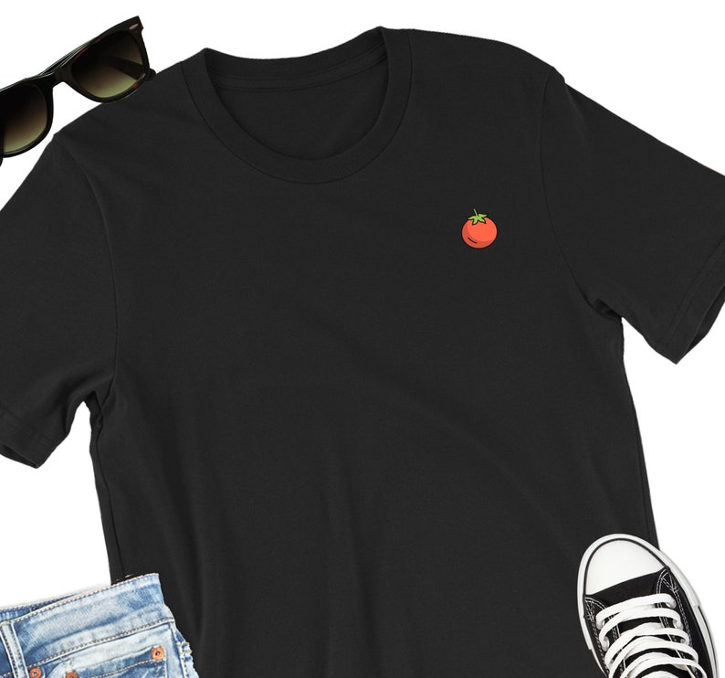 May include: A black short-sleeved t-shirt with a small red tomato embroidered on the front.