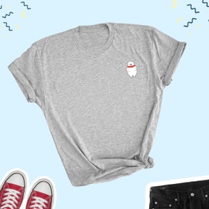 May include: A gray t-shirt with a small white polar bear wearing a red scarf on the left chest.
