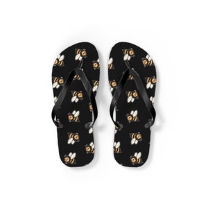 May include: A pair of black flip-flops with a repeating pattern of yellow and black cartoon bees.