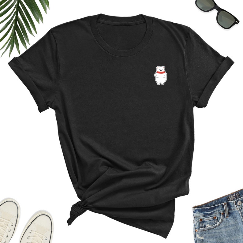 May include: Black short-sleeved t-shirt with a white polar bear wearing a red scarf on the left chest.
