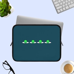 Może przedstawiać: Niebieska,  laptop sleeve z rzędem pięciu zielonych głów kosmitów, które wystają zza białej linii. Kosmici mają czarne oczy i usta.