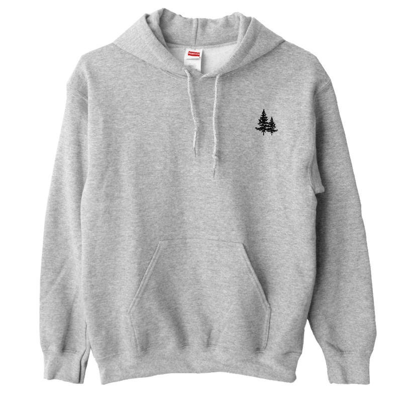 May include: A gray hooded sweatshirt with a small black embroidered design of two pine trees on the left chest.