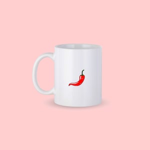 Può includere: Tazza in ceramica bianca con un'illustrazione di un peperoncino rosso.