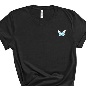 May include: Black t-shirt with a blue butterfly graphic on the left chest.