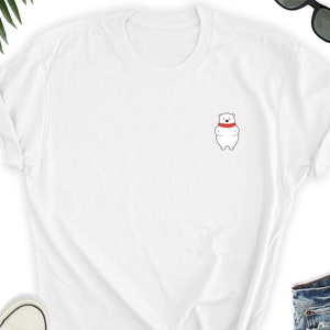 May include: White t-shirt with a small embroidered image of a white polar bear wearing a red scarf.