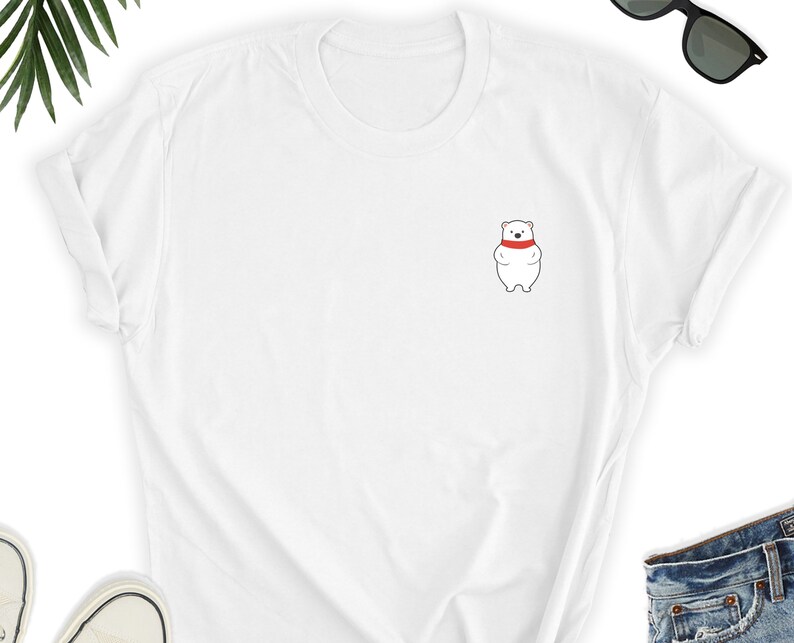 May include: White t-shirt with a small embroidered image of a white polar bear wearing a red scarf.